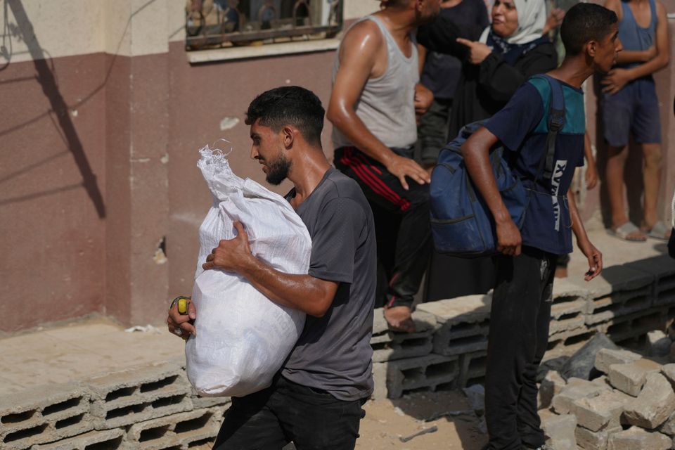 A Palestinian man collects humanitarian aid after it was airdropped into Gaza City. Photo: AP